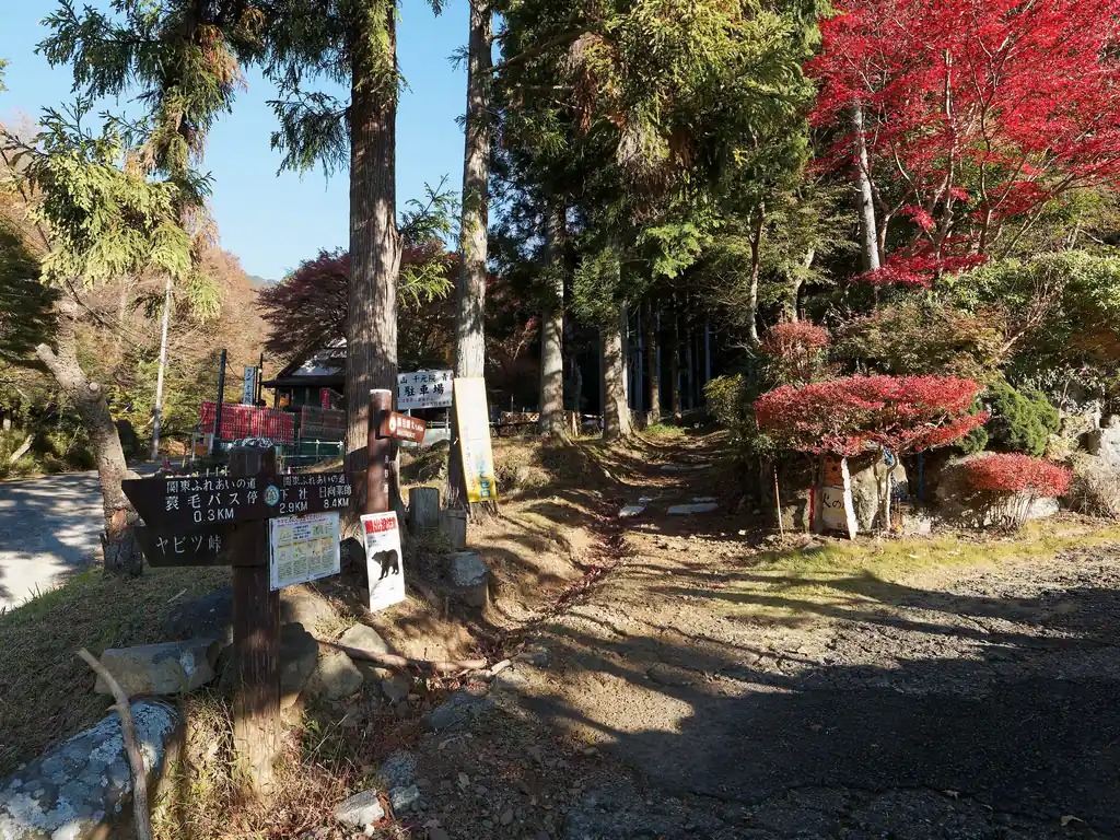 バス停から見える沢沿いの舗装路をしばらく歩いていくと、神社っぽい建物が見えてくる。登山口はその脇にある。