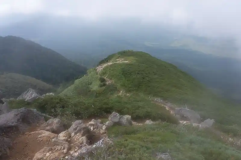 見晴新道を歩いてきた女性グループの人に、登山道の状態を聞いてみたが、泥濘はそれほどということだった。
確かにグループの足元を見てみると、それほど激しく泥だらけ、ということもなく、ハイカットシューズの下の方に泥がついているくらいだ。

これなら大丈夫そうだな、と思ったが、見晴新道方面を見てみると如何にも高度感がありそうな道が続く。
うーむ、高所恐怖症の私でも大丈夫だろうか、とドキドキしながらとりあえず歩いてみることにする。