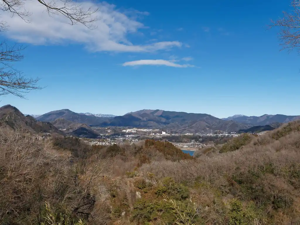 舗装路を歩いて名倉金剛山へ向かう道中、見晴らしがいいところがあったので、しばらく景色を楽しむ。

以前からずっと欲しいな、と思っていた双眼鏡を先日購入したので、それを使って遠くの山を見たりする。
奥の山がたぶん権現山あたりだと思うのだが…。左のほうがたぶん扇山・百蔵山じゃないかなあ。