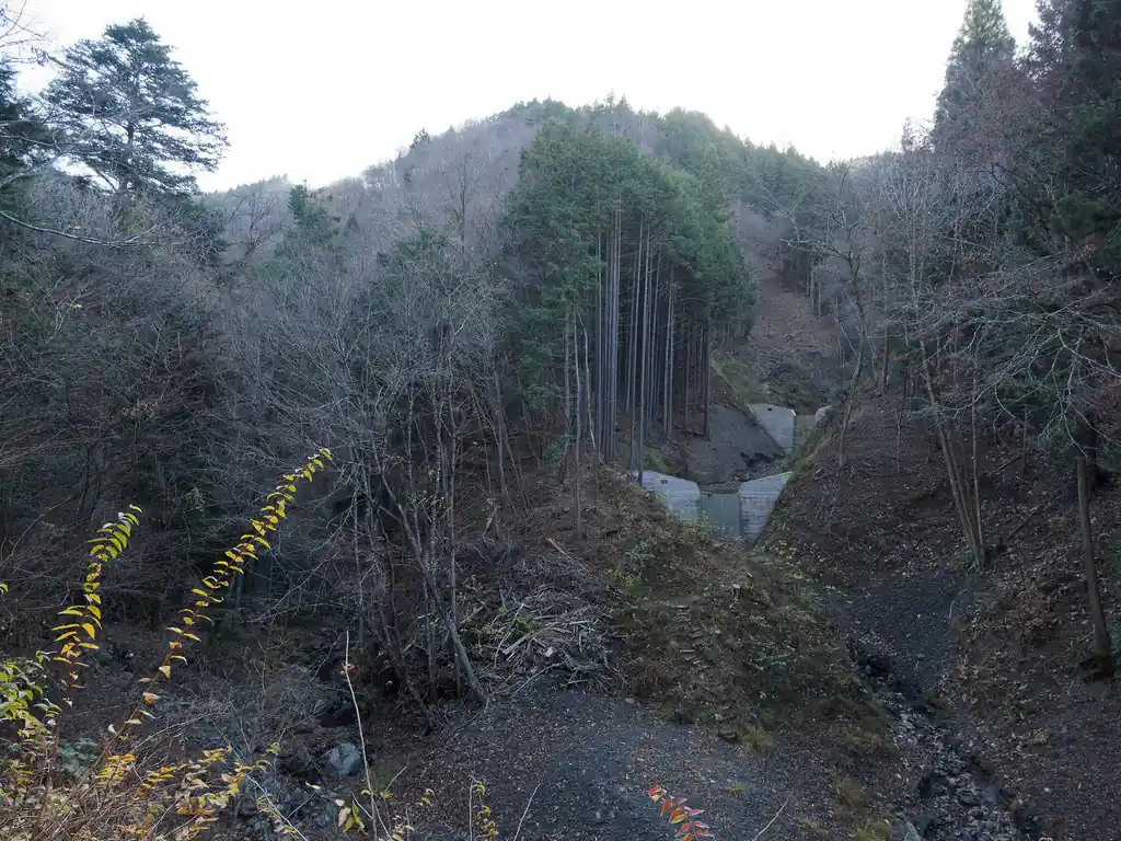 林道を歩いていくと右側に砂防ダムが見えてきた。
この砂防ダムの手前あたりに階段のようなものが見える。恐らく工事用の道か林業用の道と思われる。