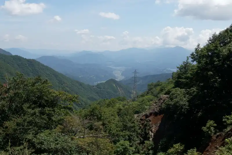 登りきってまた下ると送電鉄塔があり、ここから都留市街方面が見渡せます。
夏とはいえ、汗をたっぷりかいている上に、風の通り道とあって少し寒いくらいです。