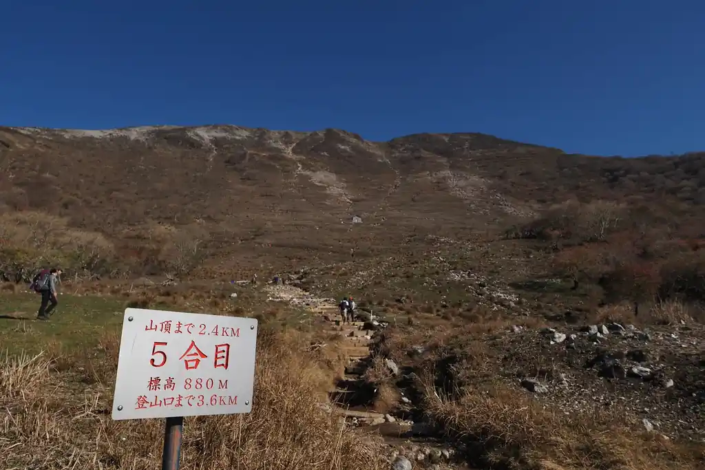 五合目。ようやく半分といったところ。ここからは登山道上に岩が増えて、山頂までの急登を登っていくことになるが、九十九折の道なので登りやすい。