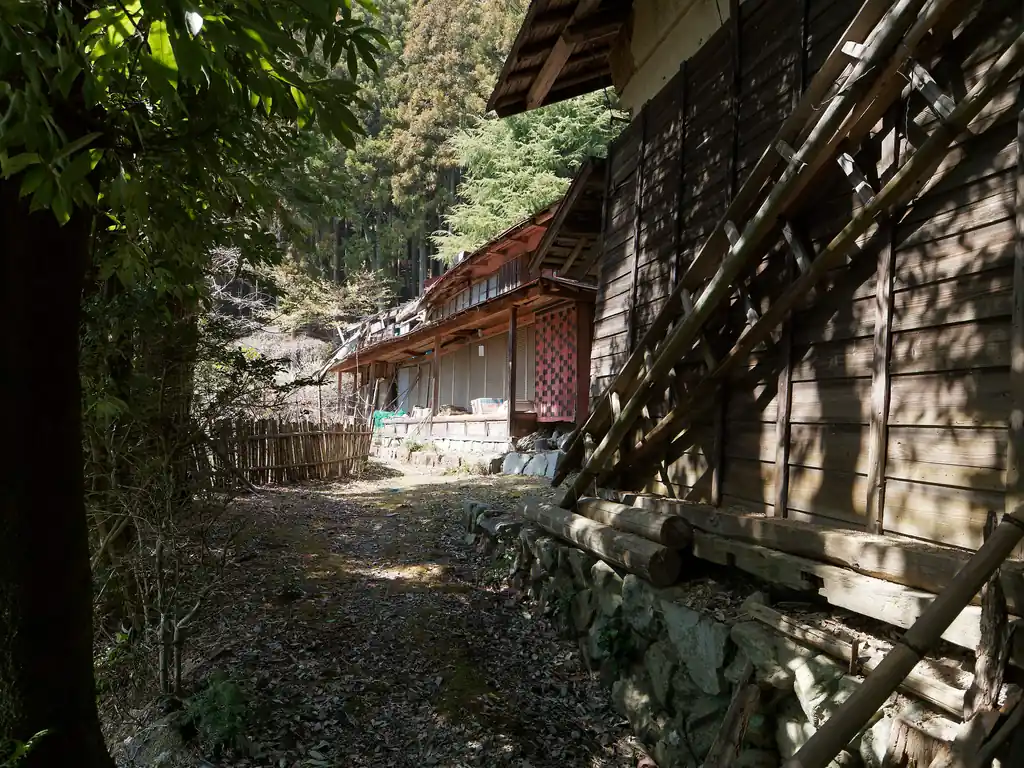 先ほど屋根が見えていた民家らしき建物。
奥の建物は屋根が潰れていて、人が住んでいる雰囲気がない。
廃屋にしては状態が良いように見えるので、最近まで人が住んでいたのかも。
