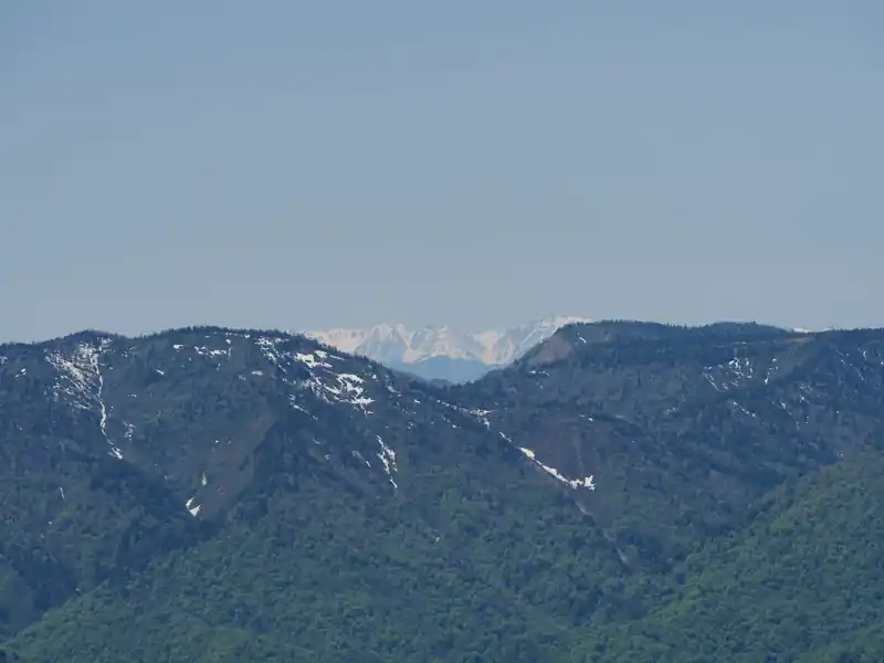 と、ここでズームして見ると積雪した山が見える。北アルプスだろうか？