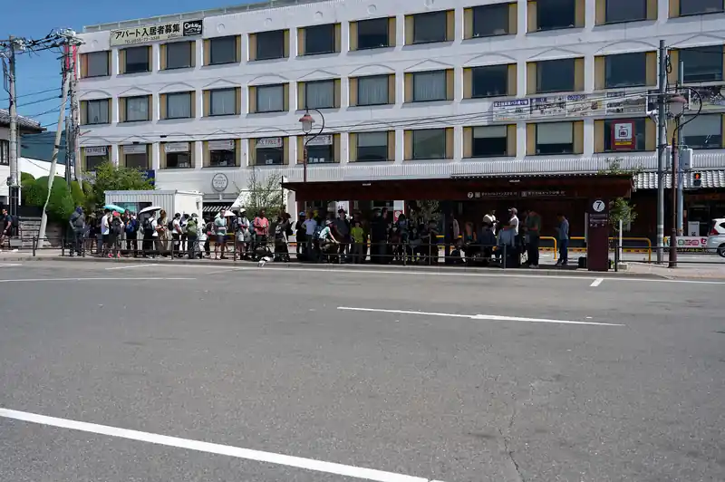 いや～河口湖駅は遠い。2時間以上かけ、数本の電車を乗り継ぎ、ようやく河口湖駅に到着しました。

既に駅周辺は外国人観光客で溢れており、天下茶屋行きのバスの向かいにある、富士スバルライン五合目行きのバス停には長い列が。
みなさん、富士山に登るんでしょうか。割とラフな格好の人も多いですが…。