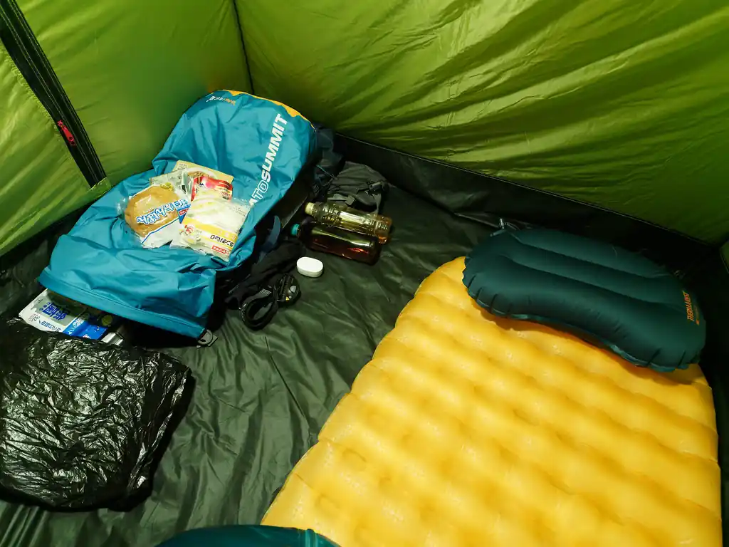 翌日は午前5時くらいになんとなく目が覚めた。というか、寒すぎてほとんど眠れなかった。
午前4時だか5時まではうつらうつらとちょっと寝ては目覚める、を繰り返していたのだが、一段と冷え込みうつらうつらとすらしなくなった。
震えてはいなかったが、寒すぎてこれはまずいな、と思った。

翌日は天気予報が悪くなっていて、山を歩いてもそれほど楽しくなさそうだったので、ここは素直に白石峠から白石車庫バス停に下山することにした。
白石車庫バス停始発のバスは午前8時10分。それに間に合うには何時くらいにはキャンプ場を出ないといけないかな…と計算してみる。
コースタイムでは今から出発しないと厳しいかもしれないくらいの時間だ。

しょうがない、と決心を決めて朝食を食べ始める。朝食はリゾットを湯煎して食べる予定だったが、今からアルコールストーブと格闘する気にはなれなかった。
そもそもテント内で火器を使うのも正直気が引ける。とはいえ、この寒い中自炊場まで移動するのも億劫である。
仕方ないので、余っていたパンを食べたが、冷蔵庫で冷やしたパンみたいに、もそもそして美味しくなかった。