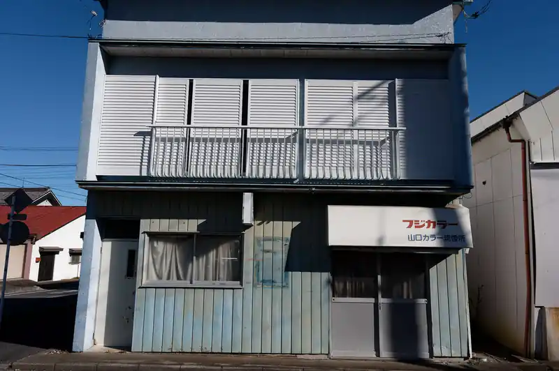 舗装路を歩いて越生駅へ向かいます。
途中フジカラーのお店があったんですが、流石にもう営業はしてない模様。
このあたりは駅前ではあるものの、閉店しているのか人影のない建物が多い。
ただ店構えはだいぶレトロなものが多く、雰囲気は好きです。もうちょっと活気が戻ってくれば良いんですが…。