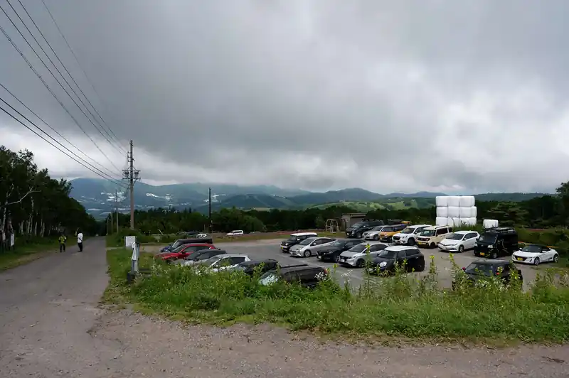 うーむ、この時点で雲が多く嫌な予感。
というか、車持ちの方々はここまで車で来れるんだから良いっすね。
この直線舗装路歩きが地味につらかった。公共交通機関のつらいところだ。