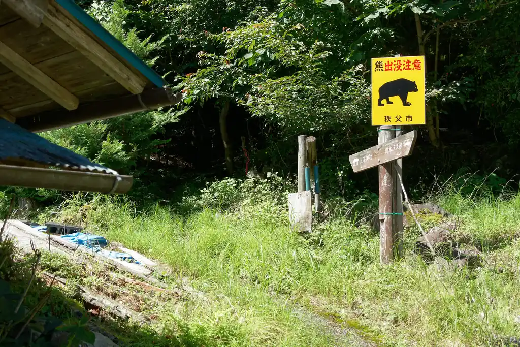 ここが登山口。熊出没注意の看板がちょっと怖い。
表参道はそこそこ人通りがあるけど、裏参道はマジで人通りが少なく、熊いそうな雰囲気の道が続くので少し怖さがあります。
熊鈴ならしてれば遭遇しない、と祈って進むしかありません。